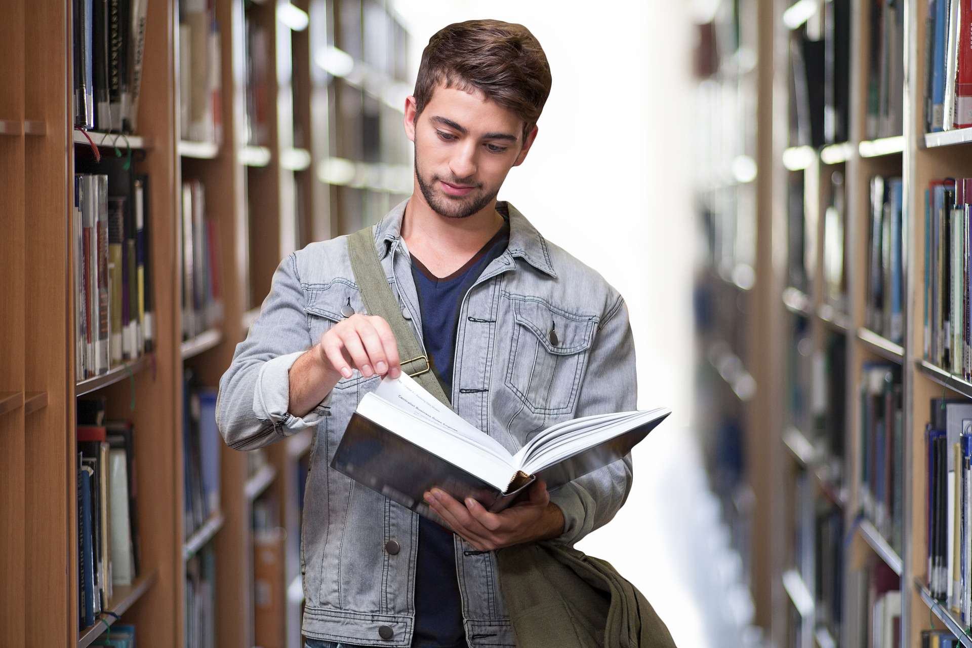 university student reading a book in the college library